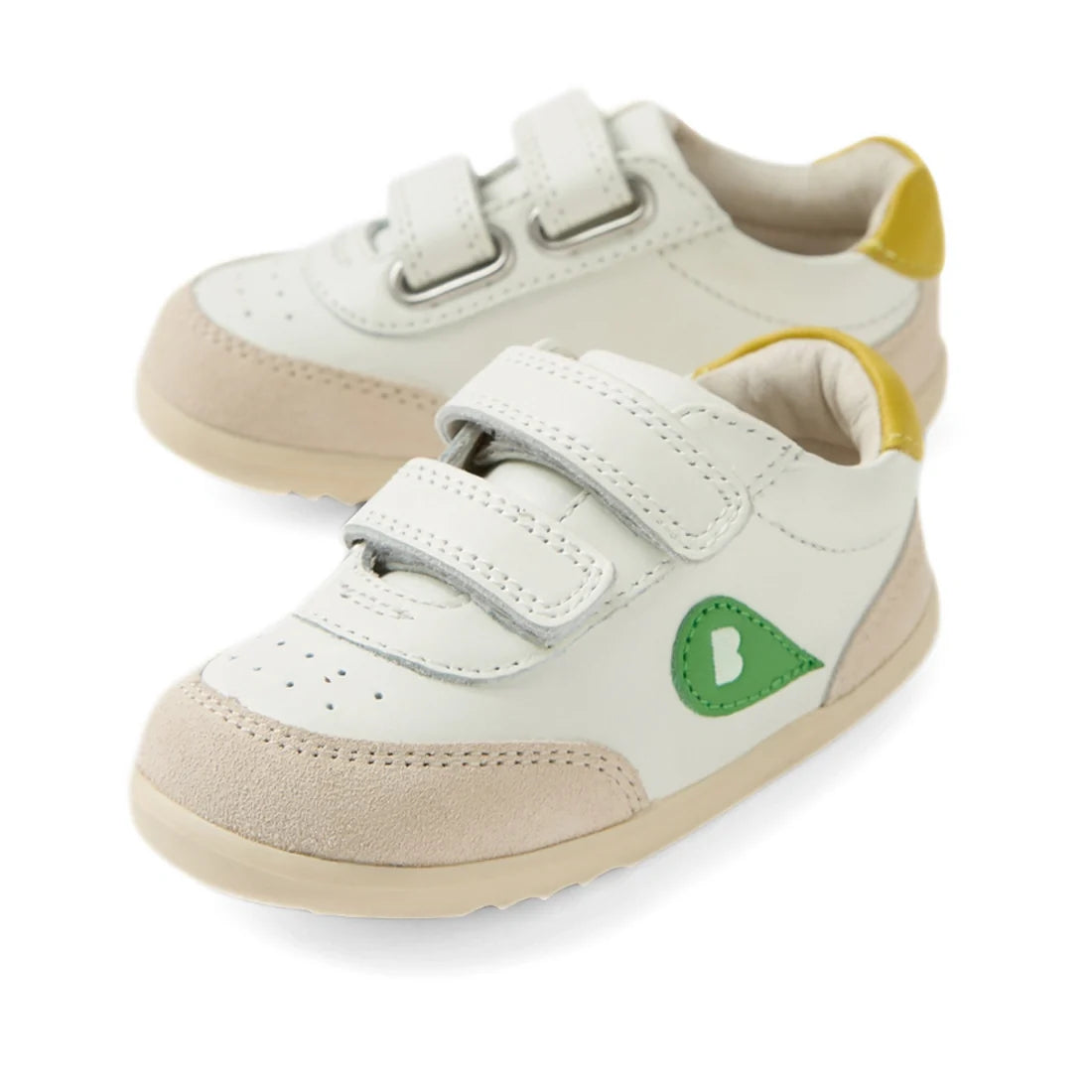 The Bobux Step Up SU Champ Sneaker First Walker in White Green is a pair of kids’ leather sneakers featuring white leather, beige suede toes, yellow heel accents, a green side logo, and two hook-and-loop straps on each shoe—perfect as first walkers for yo
