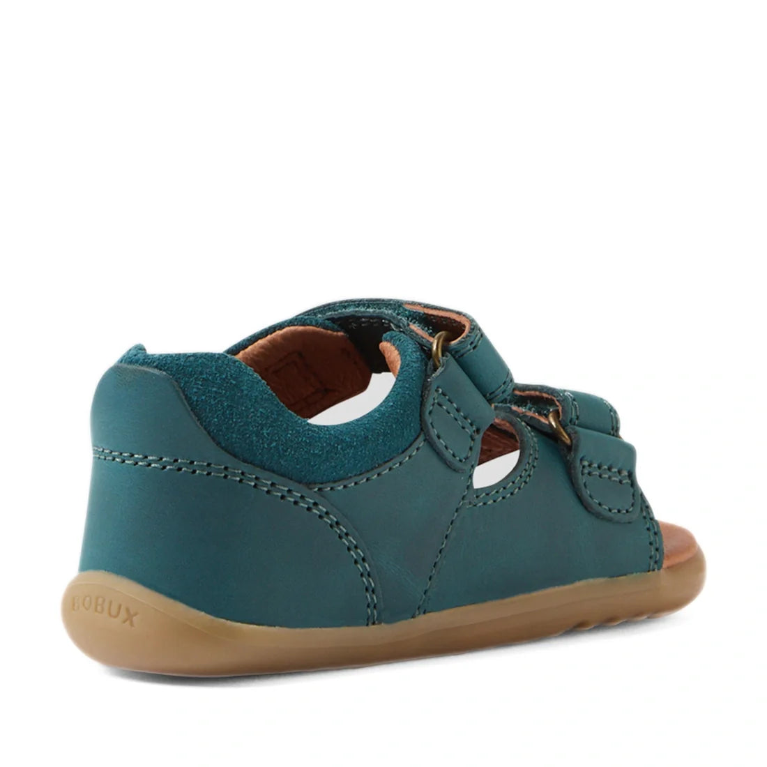 A Mediterranean green Bobux SU Step Up Driftwood First Walker Open Toe Sandal for children, designed as ideal first walking shoes, featuring leather construction with cut-outs, a tan rubber sole, and a brown interior lining. The sandal is shown from the b