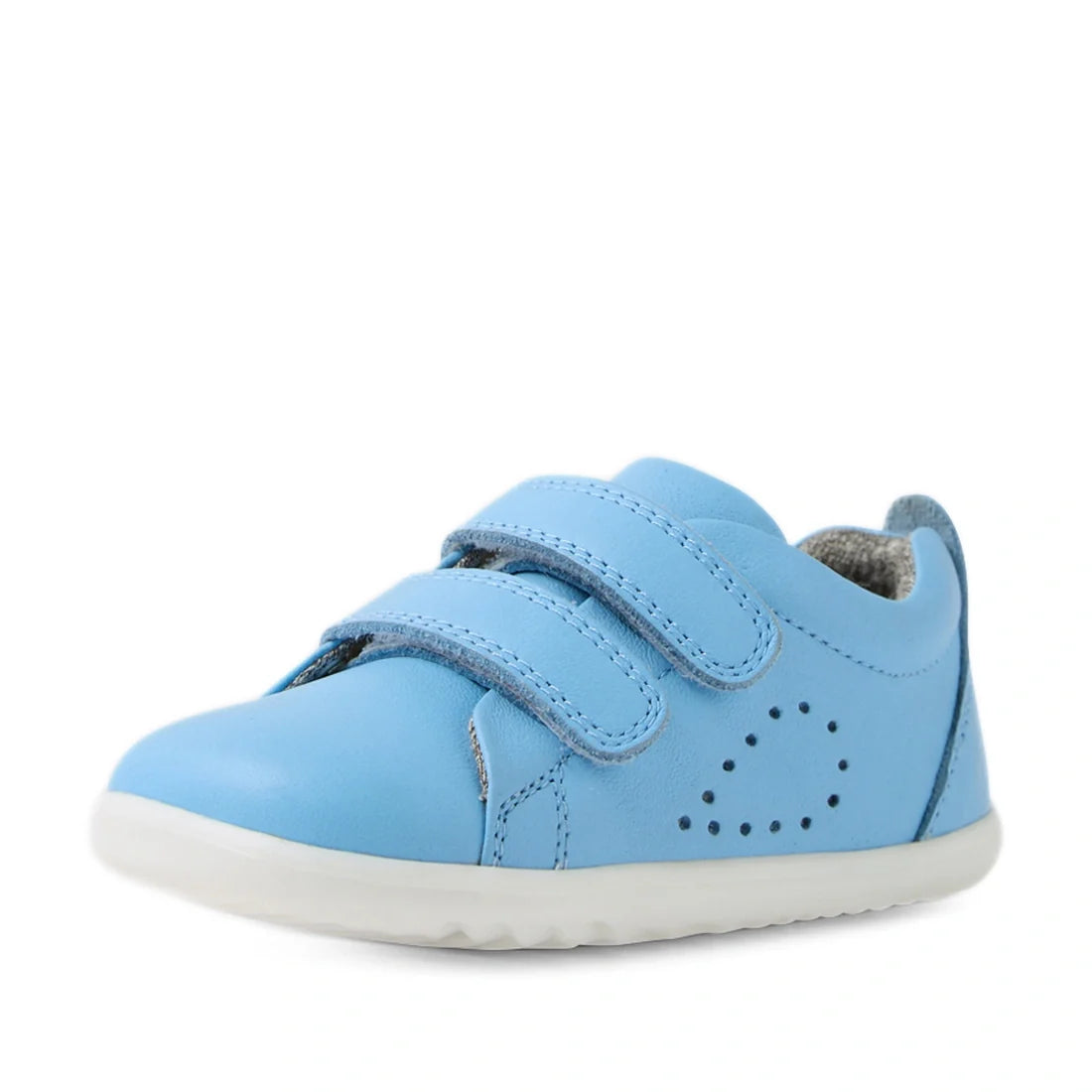 A Bobux Step Up Grass Court Trainer in Baltic Sea Blue, designed for first walkers, featuring two hook-and-loop straps, small side ventilation holes arranged in a heart shape, and a white rubber sole, displayed on a plain white background., 9420074806604,