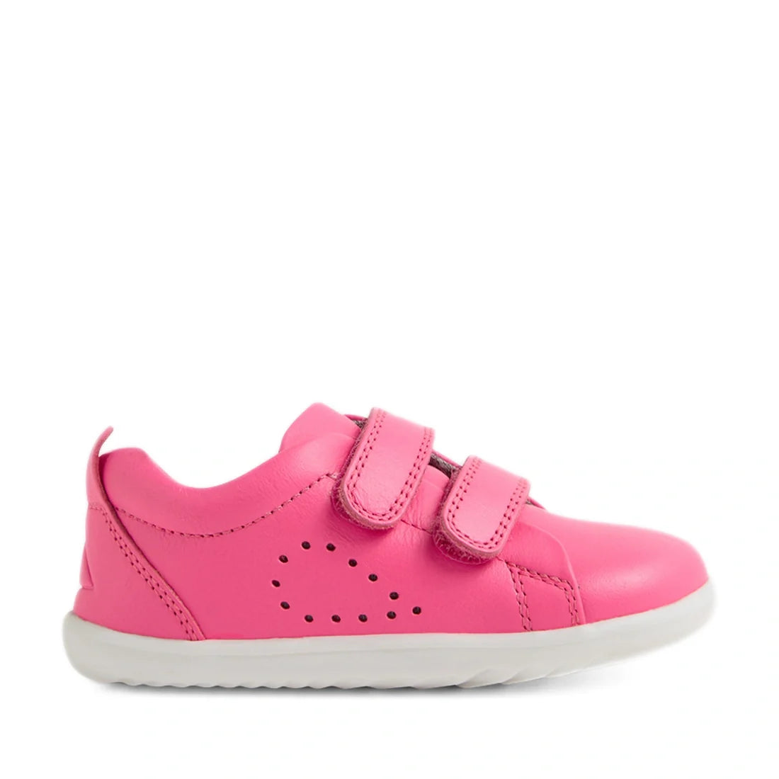 The Bobux Step Up Grass Court Trainer in Pink Lemonade is a vibrant pink leather sneaker for kids, featuring a white sole, two velcro straps, and small triangle-shaped perforations on the side. Designed as wide fit toddler shoes, they provide comfort and 