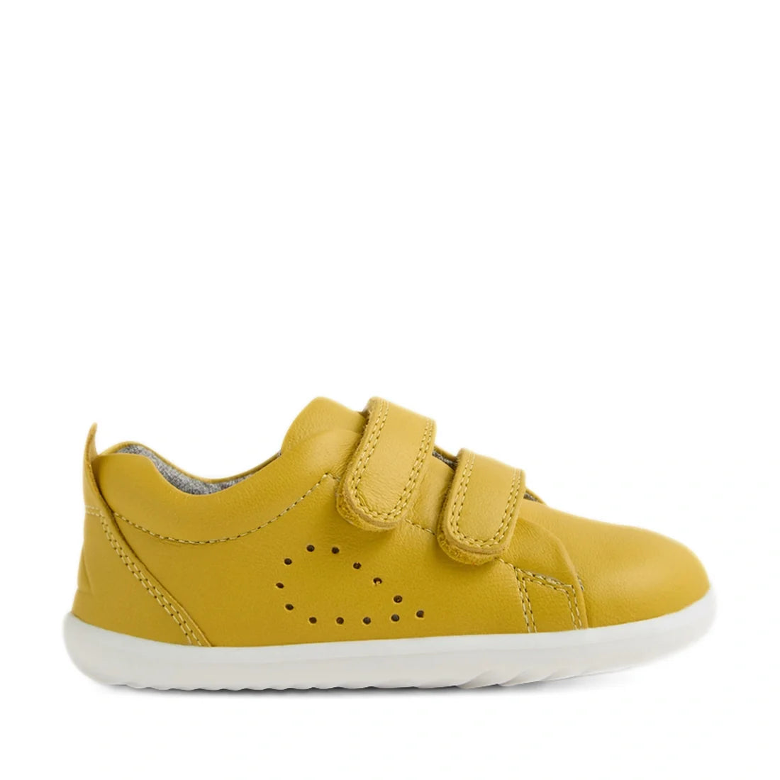 The Bobux Step Up Grass Court Trainer in Mango Mint Yellow is a toddler shoe inspired by the popular Bobux Grass Court kids’ leather sneakers. It features two hook-and-loop straps, a white sole, and a small perforated detail on the side. Shown in a side v