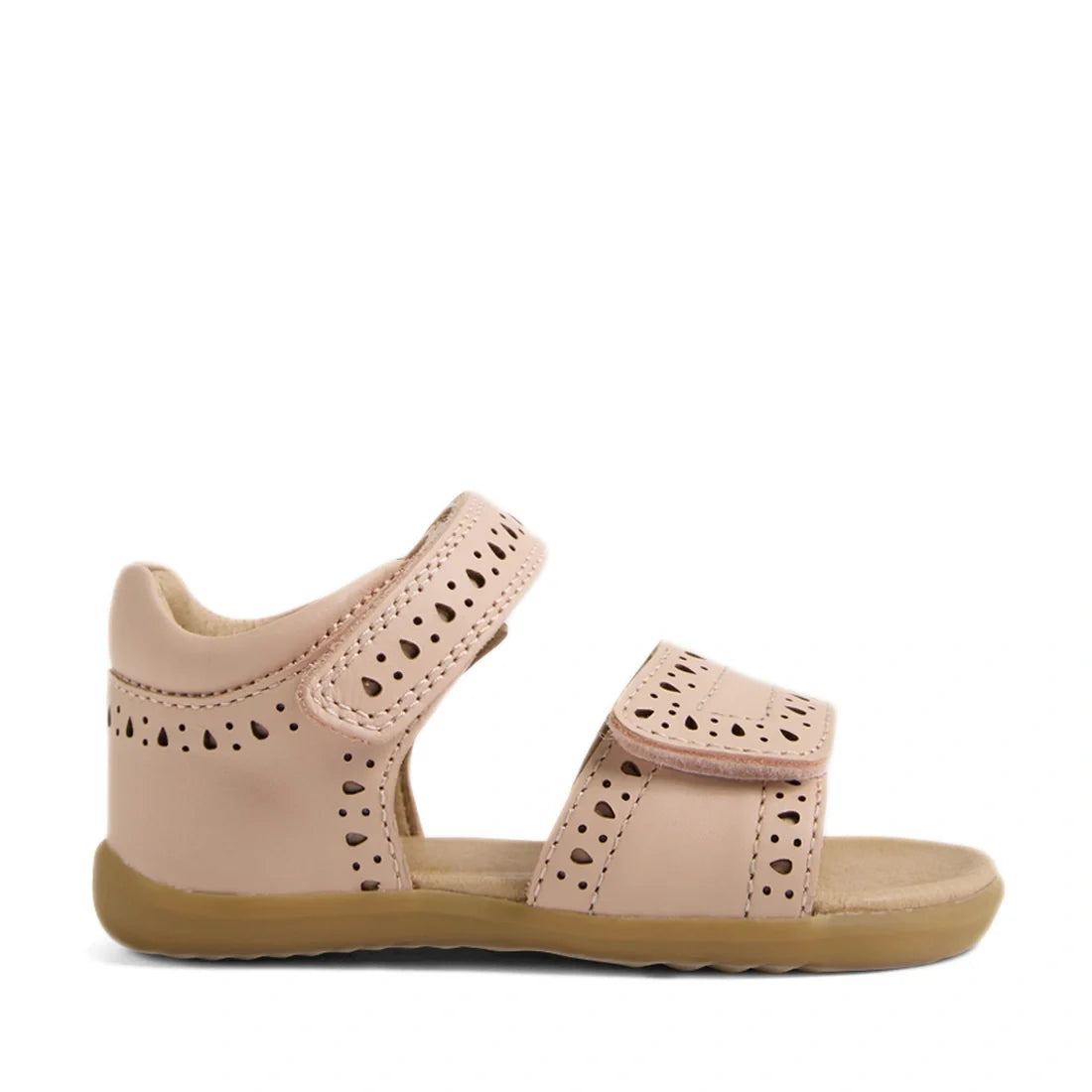 Bobux Step Up Grass Logan First Walker Sandal in Cameo Rose Pink, featuring light pink leather with perforated decorative patterns, velcro straps at the ankle and toe, and a tan rubber sole, shown from the side on a white background. Perfect as first walk