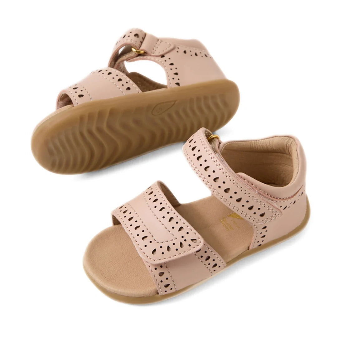 The Bobux Step Up Grass Logan First Walker Sandal in Cameo Rose Pink is a pair of girls’ leather sandals with Velcro straps, decorative cutouts, and tan rubber soles—perfect as stylish first walker sandals., 9420074849496, 9420074849502, 9420074849519