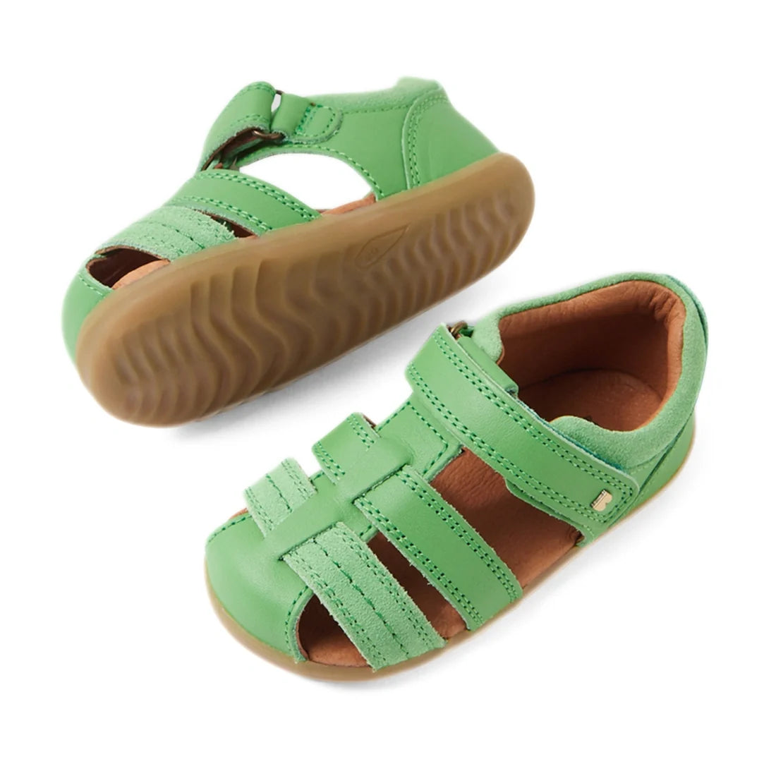 A pair of Bobux Step Up Sandal Roam Closed Toe Sandals in Retro Green, featuring velcro straps and brown rubber soles with a leather closed-toe design, are displayed from side and top angles against a white background., 9420074807205, 9420074807212, 94200