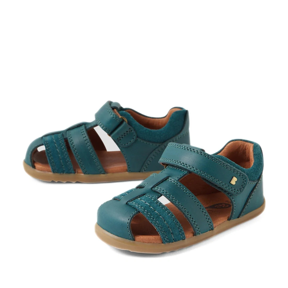 Pair of Mediterranean Green Bobux Step Up Sandal Roam Closed Toe Sandals with closed toes, velcro straps, tan insoles, and light brown rubber soles, displayed on a white background.