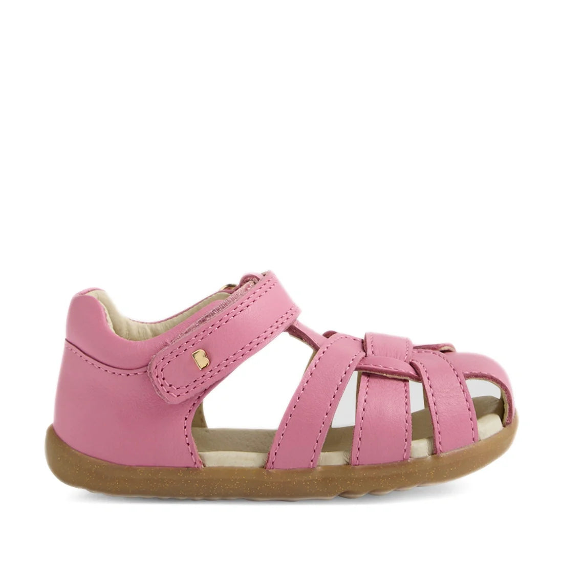The Bobux Step Up Sandal Skip Twist Closed Toe Sandals in Cashmere Rose Pink feature a closed heel, open toe, multiple crossing straps with a velcro closure, and durable brown rubber soles—making them ideal first walking leather sandals for toddlers., 942