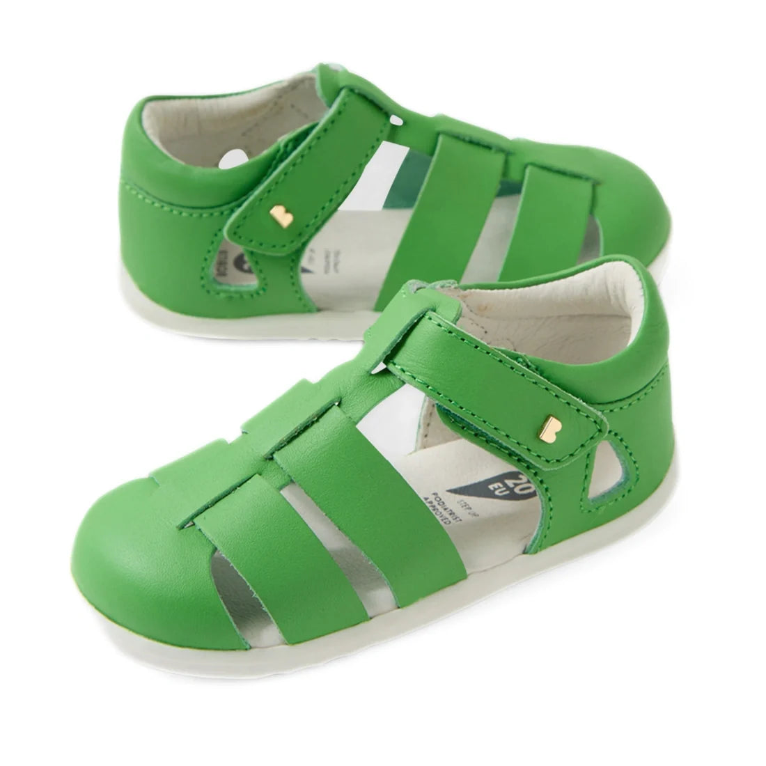 A pair of Bobux Step Up SU Toddlers Tidal Retro Green Closed Toe Sandals are displayed on a white background. These water-friendly leather sandals feature closed toes, velcro straps, and white soles, offering comfort and protection—making them the perfect