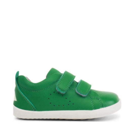 The Bobux Step Up SU Grass Court Trainer 728911 in Emerald Green is a single toddler sneaker with double Velcro straps, side perforations, and a white rubber sole—perfect as a first-walker trainer. Displayed on a plain white background.
