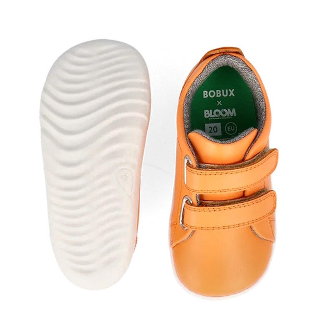 The Bobux Step Up Grass Court Trainer Apricot Crush 734209 is a pair of orange toddler shoes with two velcro straps, white wavy-textured soles, and green insoles featuring BOBUX x BLOOM branding. Shown from top and bottom., 9420075779723, 9420075779990, 9