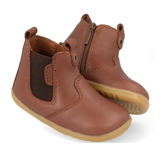 The Bobux Step Up Jodphur Boot Toffee 721926A features brown leather, elastic side panels, side zippers, pull tabs, and light brown rubber soles—a perfect unisex first walker ankle boot for toddlers shown against a white background.