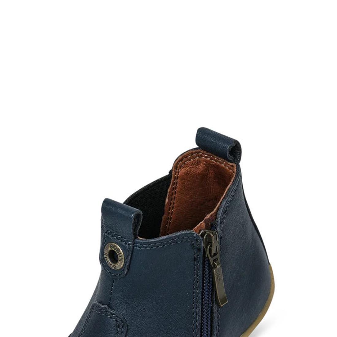 The Bobux Step Up Jodphur Boot Navy 721929A is a small navy blue leather ankle boot with a side zipper, brown lining, and front and back pull tabs—ideal as a stylish unisex first walker boot., 9420062048535, 9420062048542, 9420062048559, 9420062048566