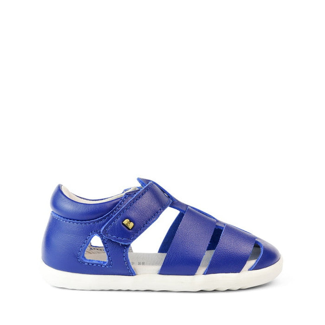 The Bobux Step Up US Tidal Blueberry Closed Toe Sandal 732501 is a single blue toddler sandal with a closed toe and heel, cutout details, velcro strap, and white sole—ideal as first walker shoes—shown on a white background., 9420068502352, 9420068502369, 