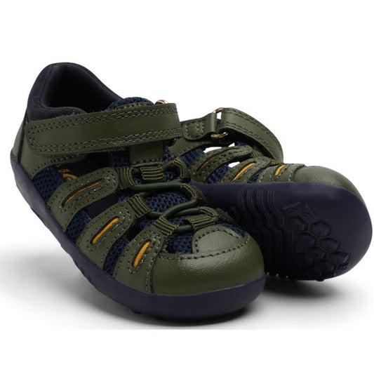 The Bobux Step Up Toddlers Summit Forest Green Navy Sandal 731610 features green and navy mesh, black soles, and yellow accents; one sandal stands upright while the other tilts to show its textured sole—ideal for adventurous toddlers.