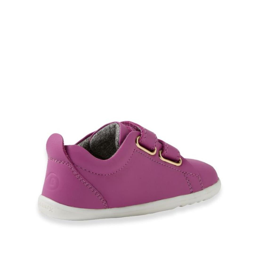 A small, bright purple Bobux Step Up Grass Court Trainer Cattleya Orchid shoe for toddlers with two velcro straps, gold eyelets, white sole, and gray lining shown from a rear side angle—perfect stylish first walker shoes., 9420074806499, 9420074806505, 94