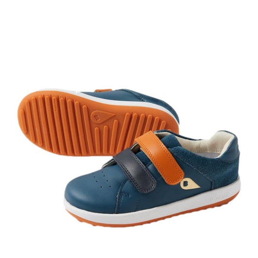 The Bobux Kid+ Breakpoint Sneaker Tidal Teal 852903 features blue uppers, orange and navy velcro straps, white midsoles, and orange rubber outsoles. One leather sneaker stands upright while the other lies on its side displaying the sole.