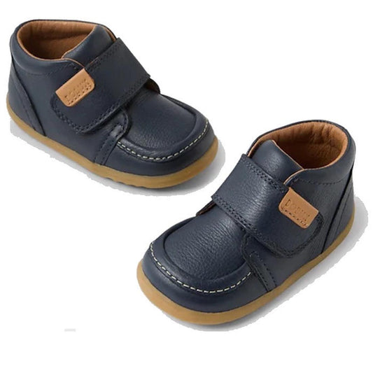 The Bobux Step Up First Walkers Grover Leather Boot in Navy features navy blue leather, tan soles, brown lining, and tan logo patches on the strap closures. These first walker shoes are shown on a white background.