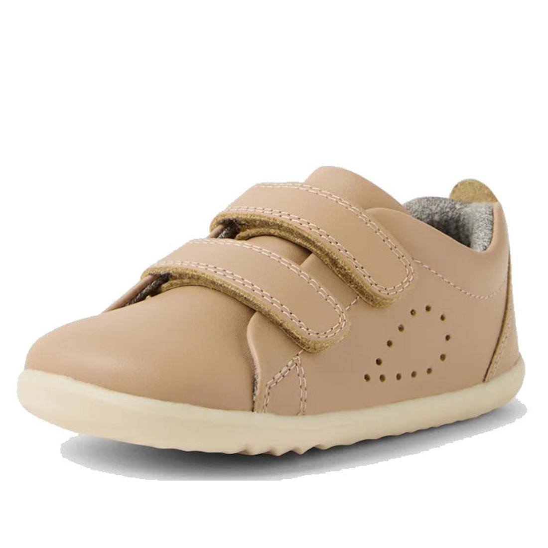 The Bobux Step Up Grass Court Trainer Warm Taupe Shoes are toddler leather sneakers in tan, featuring two velcro straps, a white rubber sole, and decorative side perforations—ideal first walker shoes for little ones., 9420074802033, 9420074802040, 9420074