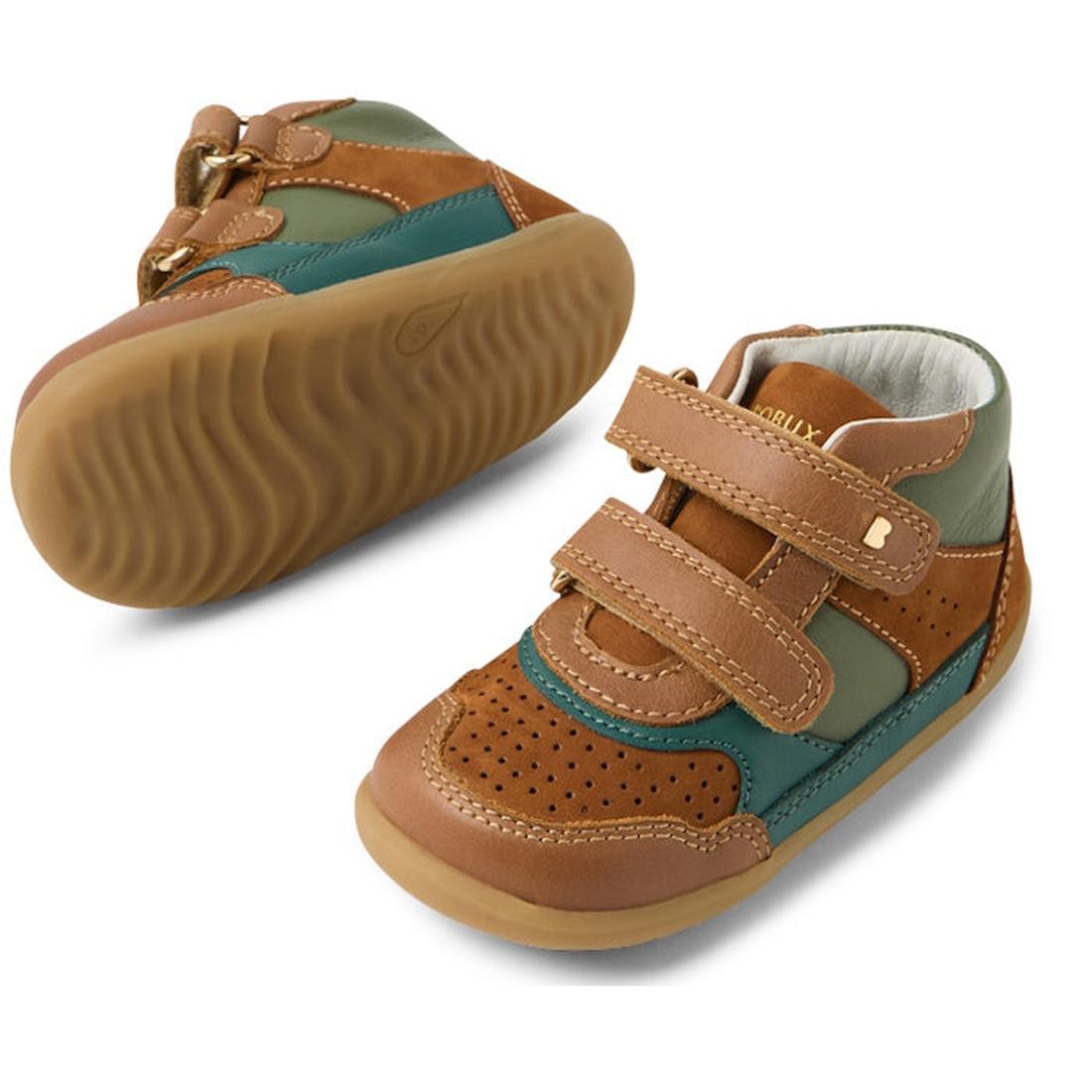 The Bobux IW Iwalk Harley Toddlers Leather Boots in tan feature brown, tan, green, and teal panels, rubber soles, adjustable velcro straps, and perforated toe detailing; one boot is upright while the other shows its sole., 9420074833464, 9420074833471, 94