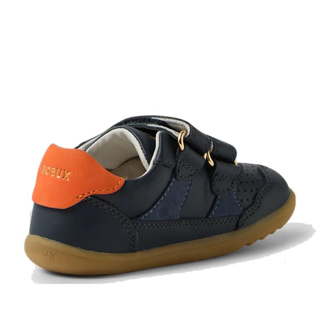 The Bobux SU Step Up Hunter Leather Toddlers Sneaker in Navy features a navy leather upper, light brown sole, orange heel accent, side perforations, and two Velcro straps, shown from the back right angle., 9420074833853, 9420074833860, 9420074833877