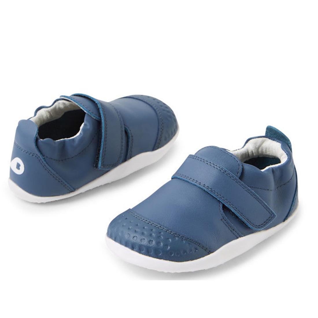The Bobux XP Xplorer First Walking Shoes Go Vintage Indigo Blue are pre-walker leather shoes with white soles and Velcro straps, featuring a flexible sole for comfort—ideal for your toddler's first steps.