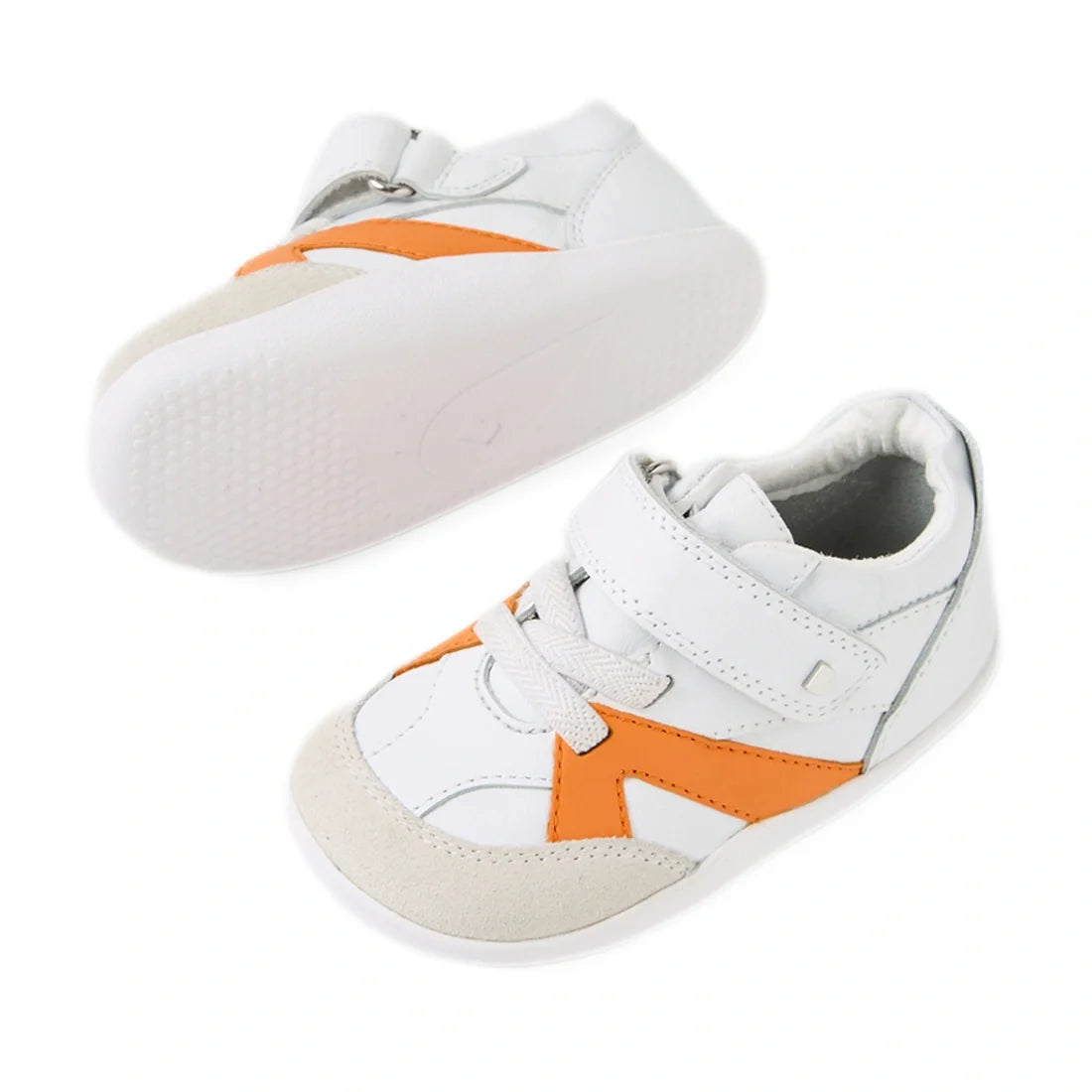 A pair of Bobux Xplorer XP Chase White Orange Peel First Walker Crawler shoes featuring a white design with orange accents, beige toe caps, white soles, and Velcro straps. These pre-walker sneakers have a flexible sole for added comfort and are shown with