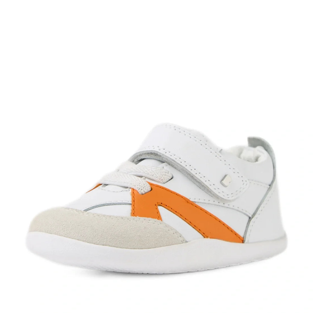 Bobux Xplorer XP Chase White Orange Peel First Walker Crawler—these white toddler sneakers with orange accents, a beige suede toe, white laces, and a Velcro strap are shown at an angle on a white background. Designed for comfort and support as pre-walker 