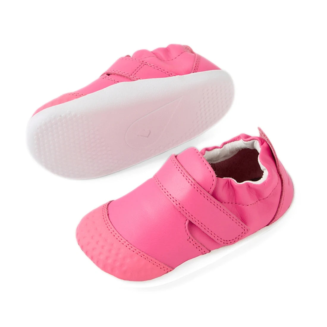 Two Bobux Xplorer XP Go Pink Lemonade First Walker Crawler shoes are shown, one upright and one on its side. These adorable pink baby shoes feature a Velcro strap, elastic around the ankle, and textured toe and sole areas for added stability., 94200748090