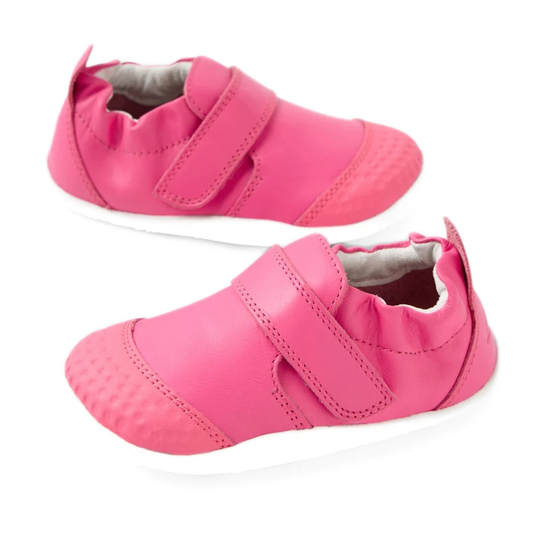 A pair of Bobux Xplorer XP Go Pink Lemonade First Walker Crawler shoes with white soles, elastic backs, and Velcro straps, displayed on a white background.