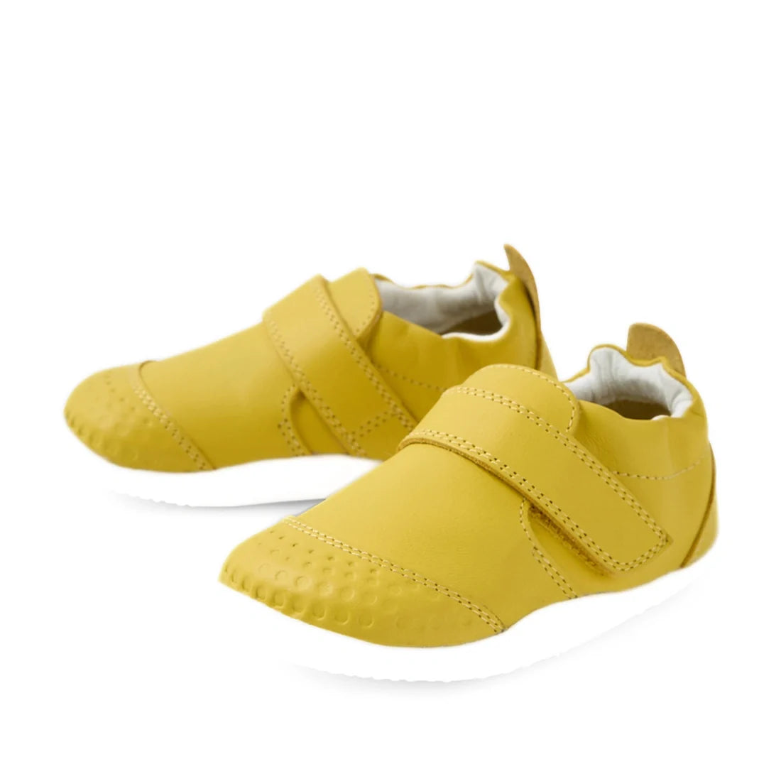 The Bobux Xplorer XP Go Mango Mint First Walker Crawler is a pair of yellow toddler walking shoes featuring hook-and-loop straps, textured toe areas, and white soles. Crafted from soft leather, these shoes are perfect as first walker footwear and are disp