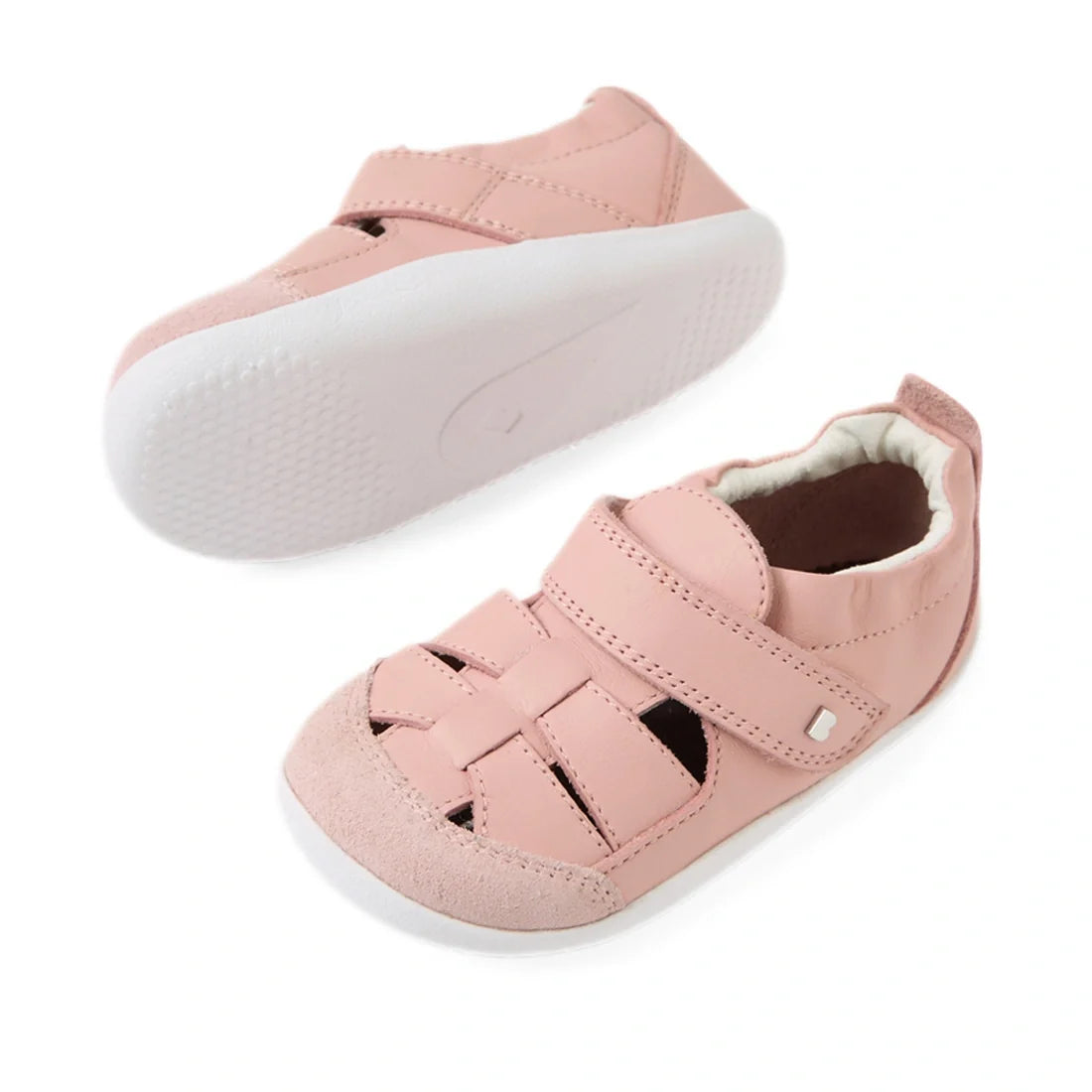 The Bobux XP Explorer Maris First Walker Sandal in Pink features two soft leather baby shoes with white soles—one highlighting the top with a velcro strap and woven fisherman sandal design, the other displaying its textured sole—making them the perfect fi