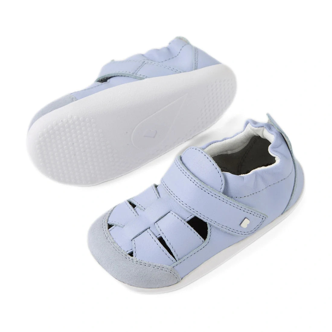 The Bobux XP Explorer Maris First Walker Sandal in Skyway Blue is a pair of light blue baby walking shoes featuring white soles, a closed toe with cutout detailing inspired by fisherman sandals, and a convenient hook-and-loop strap across the top., 942007