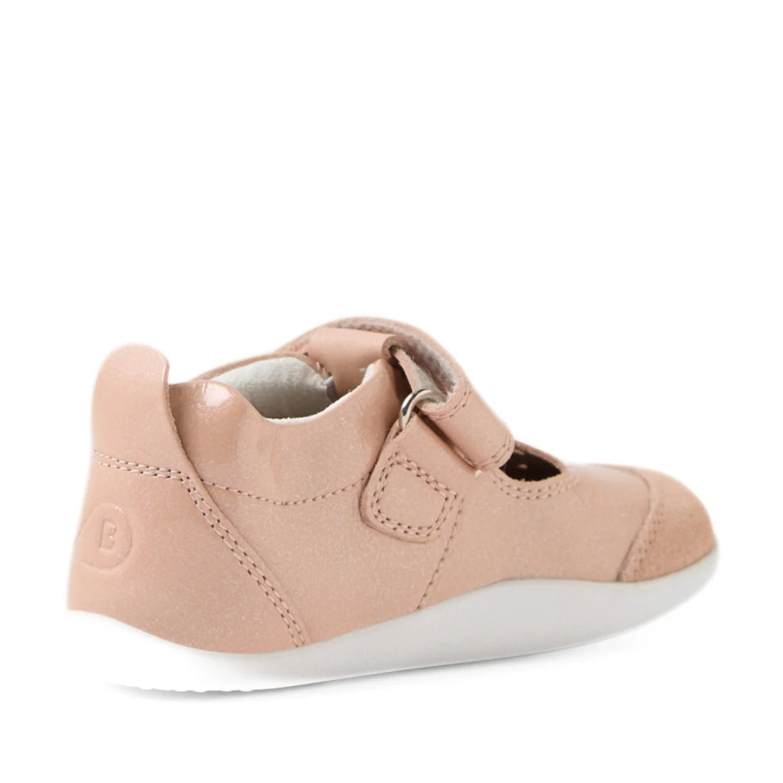 The Bobux XP Explorer Rue First Walker Sandal in Camo Rose Pink is a children’s shoe featuring a pink upper, hook-and-loop strap, and white sole. Seen from the back-left angle, this flexible sole toddler shoe has a rounded heel and soft design—ideal for l