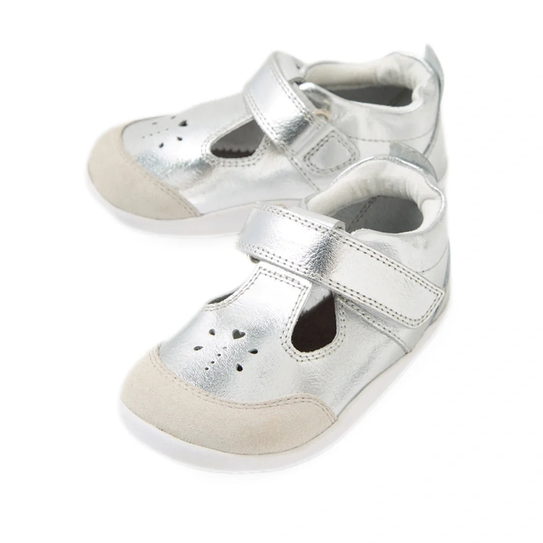 Your rewritten sentence using the product data: The Bobux XP Explorer Rue First Walker Sandal in Silver features a pair of shiny silver baby shoes with beige toe caps, white soles, and easy Velcro straps—perfect as first walking shoes. Heart-shaped cutout
