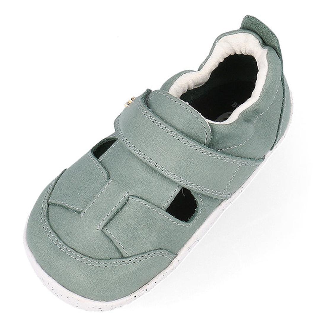 The Bobux XP Explorer Beau First Walker Sandal Sage Green 502304 is a light green toddler shoe with a closed toe, white flexible sole, and a hook-and-loop strap for comfort and easy fastening for early walkers., 9420075784499, 9420075783676, 9420075783706