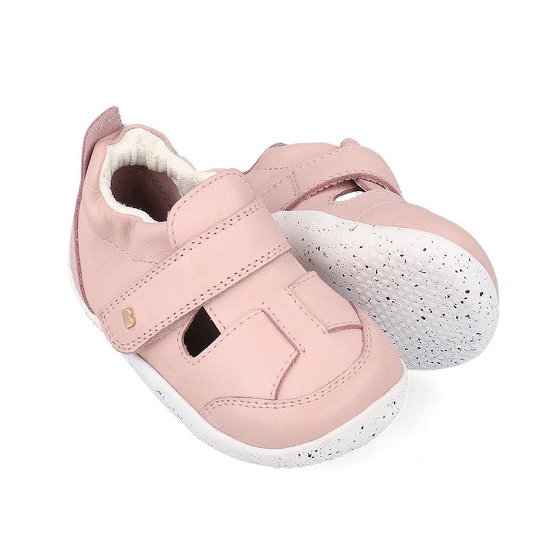 The Bobux XP Explorer Breeze First Walker Sandal Rose Water Pink 502405 features light pink, breathable cutout uppers, soft material, white textured flexible soles, and secure Velcro straps for comfort and support.