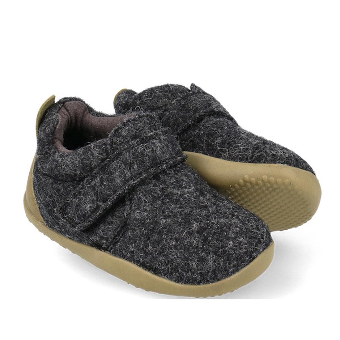 The Bobux Xplorer XP Marvel Felt in Charcoal Grey Olive features soft felt uppers, light brown rubber soles, a Velcro strap, and a suede toe cap. The baby shoes are shown with one shoe slightly overlapping the other.