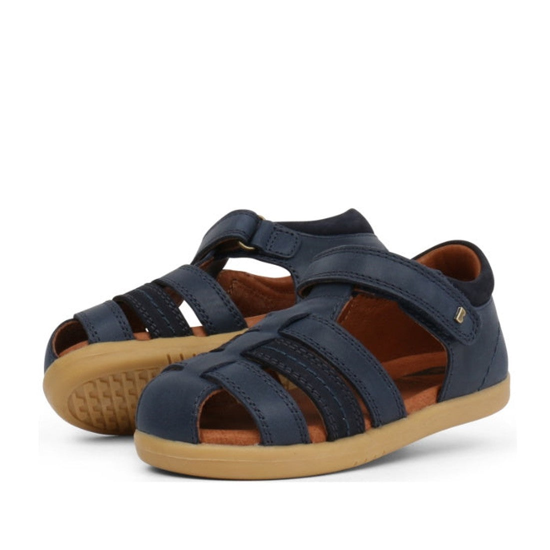 A picture of a pair of Bobux Roam sandals in the Iwalk range for toddlers aged 2 to 4 years. Closed toes in Navy with openings to allpw air flow. Heels supported wiyj a firm back to stop movement oin the heel.