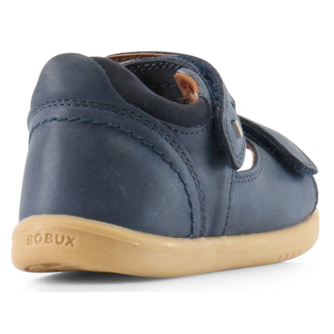 The Bobux IW Iwalk Driftwood Sandal Navy Open Toe 633601A is a navy children’s summer sandal with a tan rubber sole, adjustable Velcro strap, and BOBUX logo embossed on the heel, shown from the back., 9420062048023, 9420062048030, 9420062048047, 942006204
