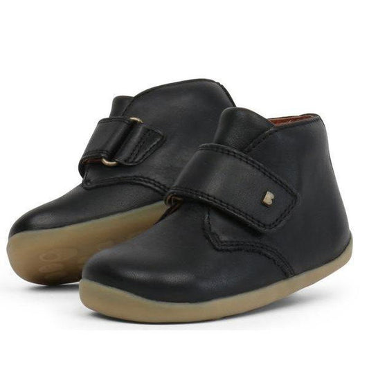The Bobux Step Up Desert Boot Black 724819A is a cozy black leather toddler boot with beige soles and easy Velcro straps for little feet.  ksnz