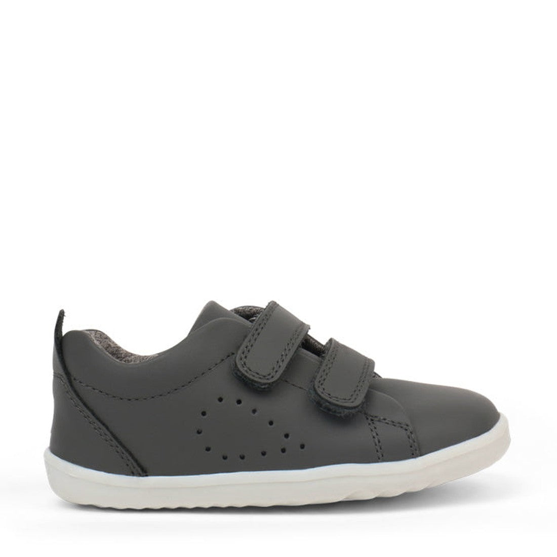The Bobux Step Up First Shoes Grass Court Trainer 728913 in Smoke Grey is a single toddler shoe in dark gray leather with two Velcro straps, side perforations, and a white rubber sole—ideal for first walkers., 9420057331574, 9420075789890, 9420075792630, 