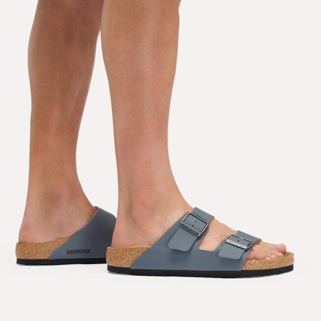Someone wearing BIRKENSTOCK Arizona Birko Flor Balsat Grey Regular Width 2 Strap Sandals stands on a light-colored surface., 51737, 51738, 51739, 4067707675807, 4067707675845, 4067707675883, 4067707675920, 4067707675968, 4067707676002, 4067707676040, 5174