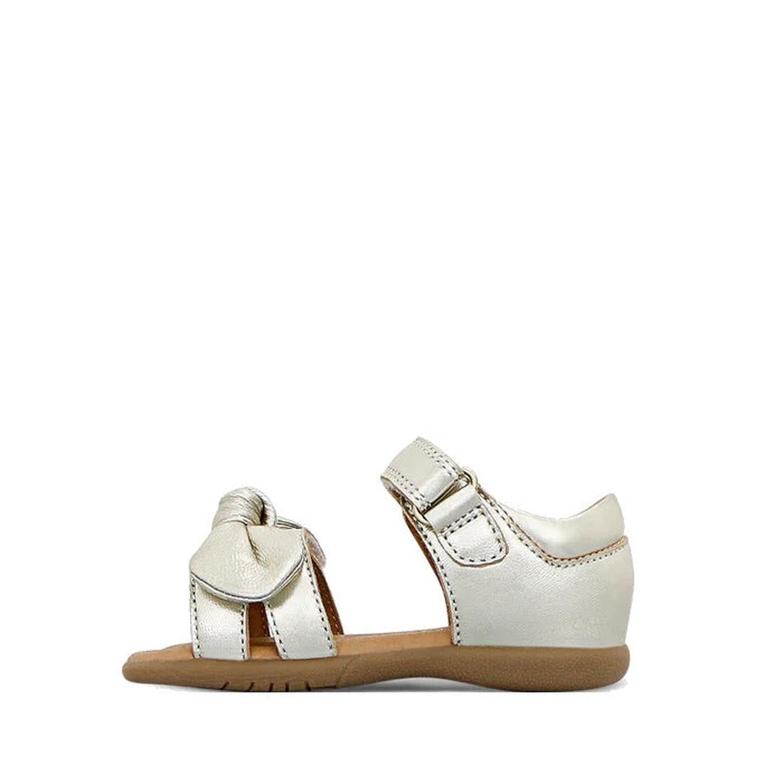 The Clarks Samara Toddlers Gold Leather Sandal in narrow width features an open toe, ankle strap, decorative front bow, tan sole with white stitching, and is shown on a white background., 40541, 9336078235183, 9336078235220, 9336078235268, 9336078235305, 