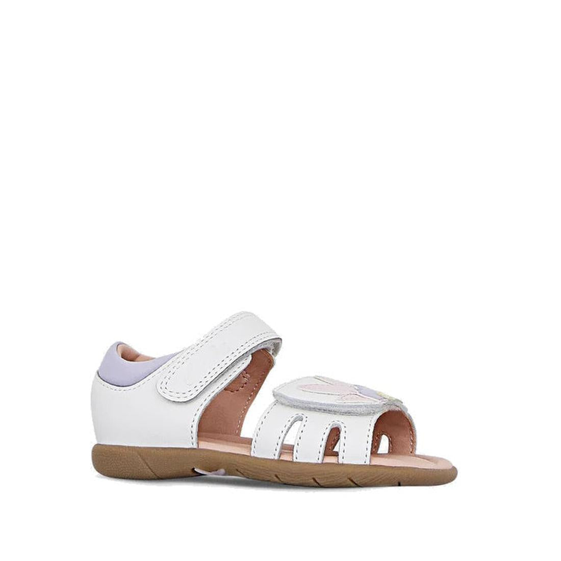 The Clarks Saskia White Toddlers Leather Sandal (E Average Width) features a closed heel, adjustable velcro ankle strap, open toe, tan rubber sole, light purple accents, and a decorative front strap detail for stylish comfort.