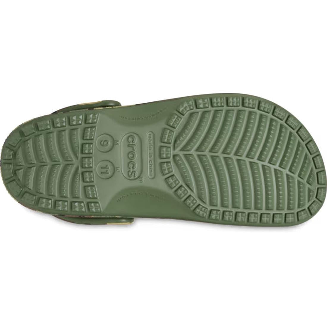The image shows the sole of a green Crocs Classic Clog Camouflage for adults, featuring a textured, non-slip pattern with deep grooves and the Crocs Comfort logo. This style is customizable with Jibbitz charms for a unique touch., 198445244957, 1984452449