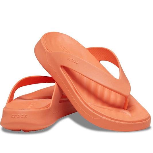 A pair of Crocs - Womens Getaway Strappy Flip Flop Sandal in Sunkissed Orange with textured footbeds and thick straps, featuring Free Feel Technology, one sandal propped against the other on a white background.