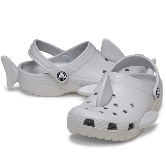 Crocs Kids I Am Shark Clog Youths in grey are playful slip-on clogs with fun shark fins, tails, secure heel straps, and comfy soles.  ksnz