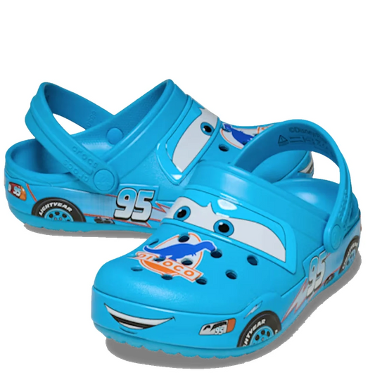 The Crocs Kids Toddlers - Classic Clog K Lightning McQueen Dinoco Blue features a vibrant blue color and a fun Lightning McQueen design from Disney’s Cars, complete with cartoon eyes and mouth on the toe, number 95, and racing graphics on the sides. These