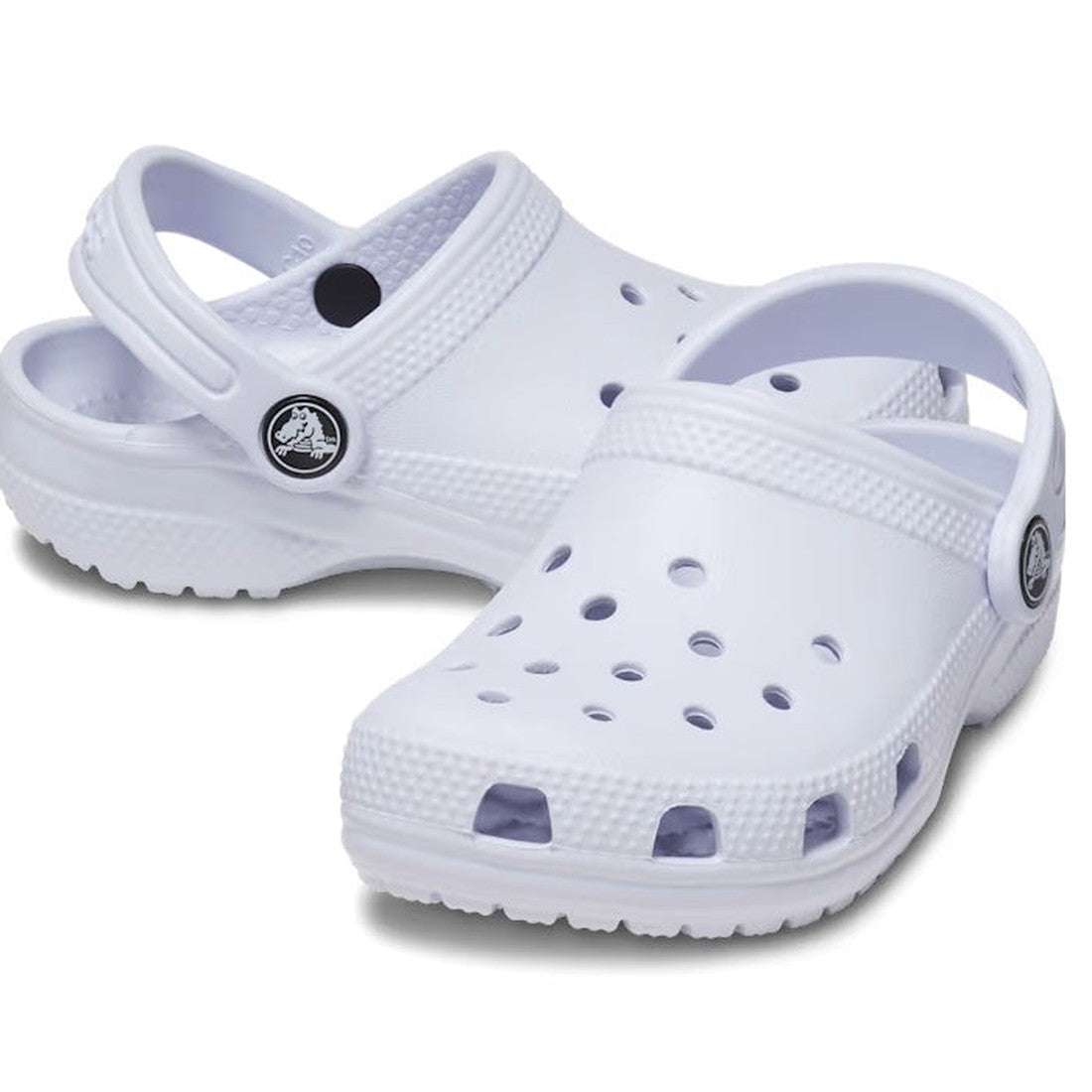 A pair of Crocs Kids - Classic Clog Dreamscape Purple for junior youths with ventilation holes, adjustable heel straps, and textured soles, displayed on a white background.