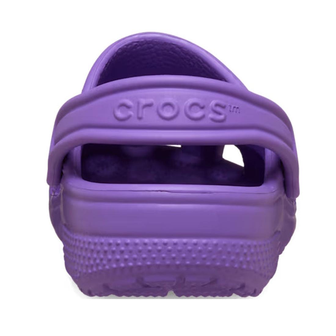 A close-up rear view of the Crocs Kids Toddlers Classic Clog in purple, showing the heel strap with "crocs" embossed, against a white background. These water-friendly shoes are perfect for everyday adventures. Available in toddler sizes., 49897, 49898, 19