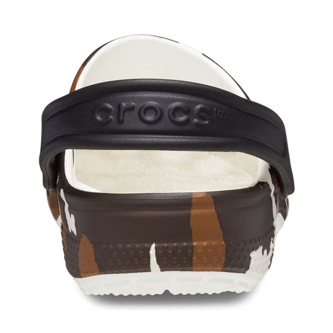 A close-up rear view of Crocs Kids - Youths Classic Clog K Cow Print White Sandals, featuring a black heel strap with the Crocs logo and a brown, white, and tan cow print pattern. The inside of the shoe is white, evoking Western style., 196265869510, 1962